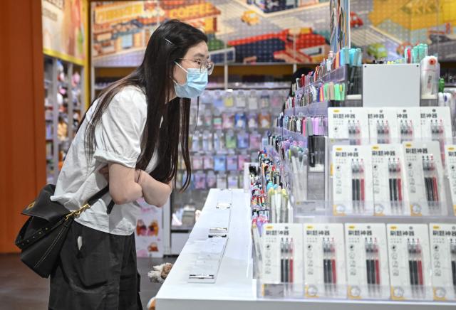 A customer looks at products in a store in Beijing on June 10, 2026. Chinese consumer prices remained stable in May, as official data on June 10, 2026 showed the impact of soaring energy prices had started to fade, while increased demand for AI-linked tech goods pushed factory gate costs up for a third straight month. (Photo by Pedro PARDO / AFP)