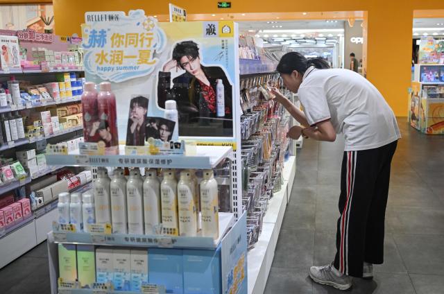 A customer looks at a product in a store in Beijing on June 10, 2026. Chinese consumer prices remained stable in May, as official data on June 10, 2026 showed the impact of soaring energy prices had started to fade, while increased demand for AI-linked tech goods pushed factory gate costs up for a third straight month. (Photo by Pedro PARDO / AFP)