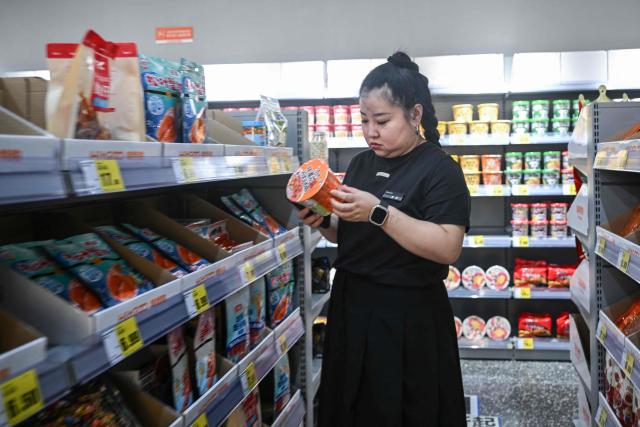 A customer looks at a product in a store in Beijing on June 10, 2026. Chinese consumer prices remained stable in May, as official data on June 10, 2026 showed the impact of soaring energy prices had started to fade, while increased demand for AI-linked tech goods pushed factory gate costs up for a third straight month. (Photo by Pedro PARDO / AFP)