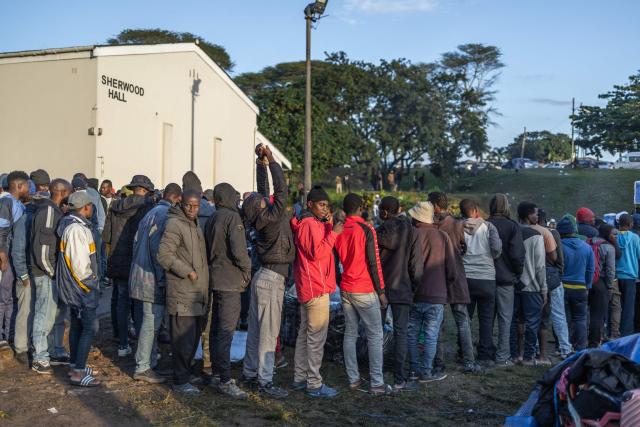 Displaced foreign nationals stand in a queue to give their personal information to volunteers at a park in Durban on June 10, 2026 after fleeing their homes amid fears of xenophobic attacks. Hundreds of foreign nationals await repatriation to Malawi from South Africa following xenophobic violence in the country. Foreign nationals have told of intimidation and beatings by mobs going door-to-door to tell them to leave by June 30, a "deadline" regularly broadcast across social media, even though it has no official backing. Ghana, Mozambique and Malawi are among countries that have repatriated hundreds of their nationals this month, most of whom South Africa says did not have the correct documentation to be in the country. (Photo by RAJESH JANTILAL / AFP)