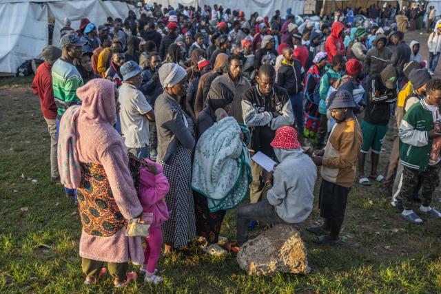 Displaced foreign nationals stand in a queue to give their personal information to volunteers at a park in Durban on June 10, 2026 after fleeing their homes amid fears of xenophobic attacks. Hundreds of foreign nationals await repatriation to Malawi from South Africa following xenophobic violence in the country. Foreign nationals have told of intimidation and beatings by mobs going door-to-door to tell them to leave by June 30, a "deadline" regularly broadcast across social media, even though it has no official backing. Ghana, Mozambique and Malawi are among countries that have repatriated hundreds of their nationals this month, most of whom South Africa says did not have the correct documentation to be in the country. (Photo by RAJESH JANTILAL / AFP)