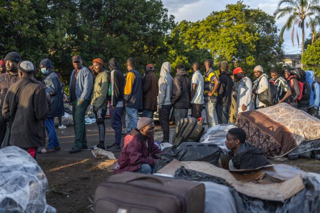Displaced foreign nationals stand in a queue to give their personal information to volunteers at a park in Durban on June 10, 2026 after fleeing their homes amid fears of xenophobic attacks. Hundreds of foreign nationals await repatriation to Malawi from South Africa following xenophobic violence in the country. Foreign nationals have told of intimidation and beatings by mobs going door-to-door to tell them to leave by June 30, a "deadline" regularly broadcast across social media, even though it has no official backing. Ghana, Mozambique and Malawi are among countries that have repatriated hundreds of their nationals this month, most of whom South Africa says did not have the correct documentation to be in the country. (Photo by RAJESH JANTILAL / AFP)
