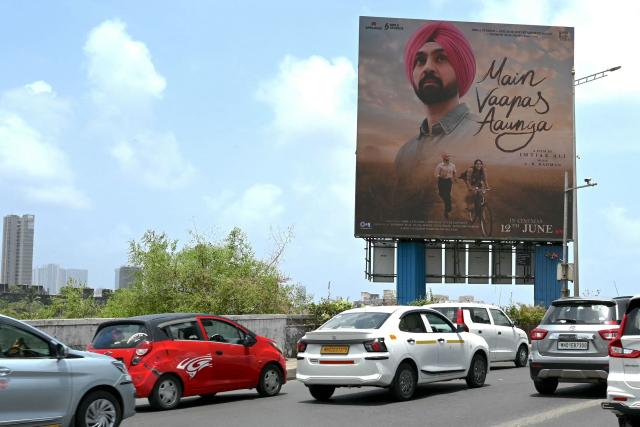 Commuters drive past a billboard of upcoming Bollywood film 'Main Vaapas Aaunga' in Mumbai on June 10, 2026. (Photo by Indranil Mukherjee / AFP)