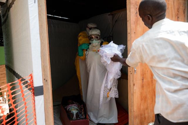 Volunteers from the Democratic Republic of Congo Red Cross prepare the body of a deceased child suspected of having died from Ebola virus for a funeral, at Salama Hospital in Bunia on June 9, 2026. (Photo by Jospin Mwisha / AFP)