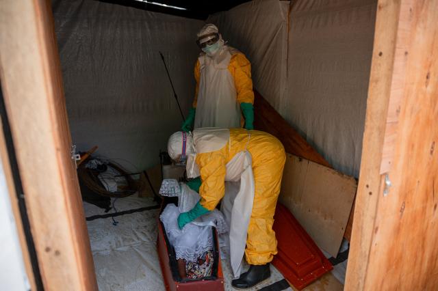 TOPSHOT - Volunteers from the Democratic Republic of Congo Red Cross prepare the body of a deceased child suspected of having died from Ebola virus for a funeral, at Salama Hospital in Bunia on June 9, 2026. (Photo by Jospin Mwisha / AFP)