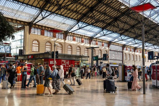 Travelers walk with luggage at the Saint-Charles train station in Marseille, southern France, on June 10, 2026. Some TGV high-speed trains are cancelled on June 10, morning, as well as regional and suburban trains, which are increasingly open to competition, as part of a 24-hour strike organized by SNCF unions. Traffic on June 10 morning is in line with forecasts, SNCF Voyageurs told AFP: regional traffic—the “everyday trains”—is “severely disrupted,” and on long-distance routes an average of one in three TGVs has been cancelled, along with one in two Intercitйs trains. (Photo by MIGUEL MEDINA / AFP)