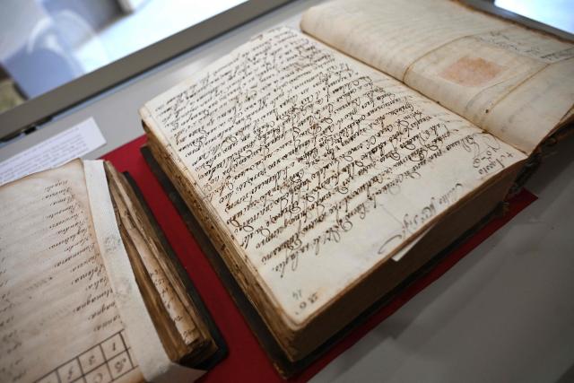This photograph taken on June 5, 2026 shows manuscripts diplayed in a case during a press preview as part of the exhibition "Atto Melani (16261714). The Secret Voice of Power," at the Labronica Library of Villa Fabbricotti in Livorno on June 5, 2026. A celebrated singer in the courts of Tuscany, Venice, Rome, and France, a protégé of Cardinal Mazarin and close associate of the Sun King, Louis XIV of France, Atto Melani transformed his theatrical success into an extraordinary diplomatic career. Castrated as a child, he constantly struggled between public prestige and the human burden of his condition, yet he managed to become a political mediator, informer, and protagonist in the conclaves that marked the history of the papacy between 1667 and 1700. (Photo by Andreas SOLARO / AFP)