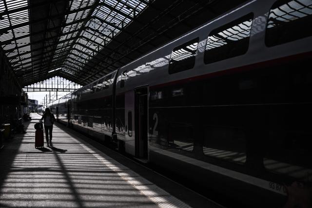 A passenger walks with luggage on a train platform at a railway station in Beziers, southern France, on June 10, 2026. Some TGV high-speed trains are cancelled on June 10, morning, as well as regional and suburban trains, as part of a 24-hour strike organized by SNCF unions as the four representative rail unions — CGT-Cheminots, UNSA-Ferroviaire, SUD-Rail and CFDT-Cheminots — called a one-day walkout for their first joint national action since late 2024, to denounce internal restructuring and demand higher wages. (Photo by Gabriel BOUYS / AFP)