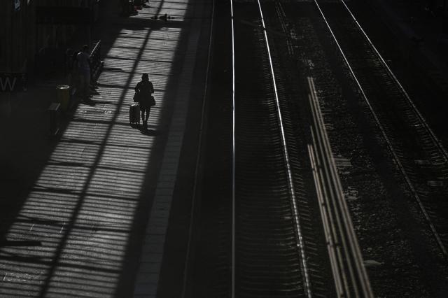 A passenger walks with luggage on a train platform at a railway station in Beziers, southern France, on June 10, 2026. Some TGV high-speed trains are cancelled on June 10, morning, as well as regional and suburban trains, as part of a 24-hour strike organized by SNCF unions as the four representative rail unions — CGT-Cheminots, UNSA-Ferroviaire, SUD-Rail and CFDT-Cheminots — called a one-day walkout for their first joint national action since late 2024, to denounce internal restructuring and demand higher wages. (Photo by Gabriel BOUYS / AFP)