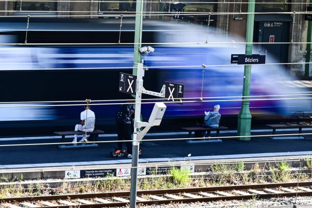 This slow shutter photograph shows passengers sitting on a train platform as a train passes by at a railway station in Beziers, southern France, on June 10, 2026. Some TGV high-speed trains are cancelled on June 10, morning, as well as regional and suburban trains, as part of a 24-hour strike organized by SNCF unions as the four representative rail unions — CGT-Cheminots, UNSA-Ferroviaire, SUD-Rail and CFDT-Cheminots — called a one-day walkout for their first joint national action since late 2024, to denounce internal restructuring and demand higher wages. (Photo by Gabriel BOUYS / AFP)