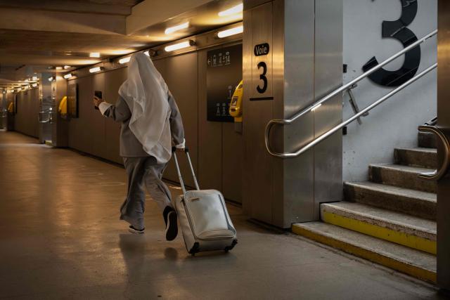 A veiled woman runs with her suitcase through an underground passageway of the Saint-Jean railway station during a nationwide strike of French national railway company SNCF workers in Bordeaux, south-western France, on June 10, 2026. Some TGV high-speed trains are cancelled on June 10, morning, as well as regional and suburban trains, as part of a 24-hour strike organized by SNCF unions as the four representative rail unions — CGT-Cheminots, UNSA-Ferroviaire, SUD-Rail and CFDT-Cheminots — called a one-day walkout for their first joint national action since late 2024, to denounce internal restructuring and demand higher wages. (Photo by Philippe LOPEZ / AFP)