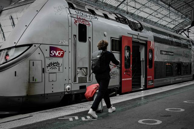 A traveller hurries to board a regional TER train of the Nouvelle-Aquitaine region at the Saint-Jean railway station during a nationwide strike of French national railway company SNCF workers in Bordeaux, south-western France, on June 10, 2026. Some TGV high-speed trains are cancelled on June 10, morning, as well as regional and suburban trains, as part of a 24-hour strike organized by SNCF unions as the four representative rail unions — CGT-Cheminots, UNSA-Ferroviaire, SUD-Rail and CFDT-Cheminots — called a one-day walkout for their first joint national action since late 2024, to denounce internal restructuring and demand higher wages. (Photo by Philippe LOPEZ / AFP)