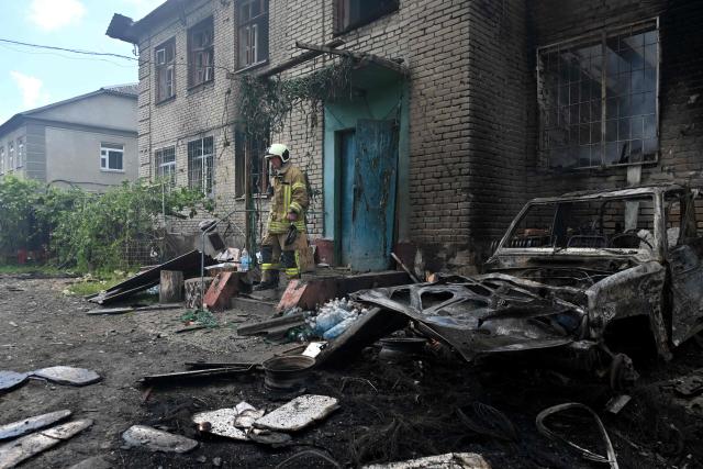 A Ukrainian rescuer stands on the porch of a damaged building following an air attack in Kharkiv on June 10, 2026, amid the Russian invasion of Ukraine. (Photo by SERGEY BOBOK / AFP)