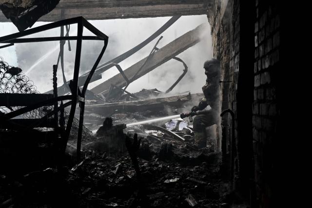 A Ukrainian rescuer works to extinguish a fire in a building following an air attack in Kharkiv on June 10, 2026, amid the Russian invasion of Ukraine. (Photo by SERGEY BOBOK / AFP)