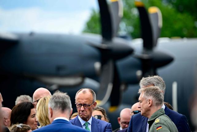 German Chancellor Friedrich Merz (C) speaks with German Air Force personell during the opening day of International Aerospace Exhibition (ILA) in Schoenefeld, near Berlin on June 10, 2026. (Photo by Tobias SCHWARZ / AFP)