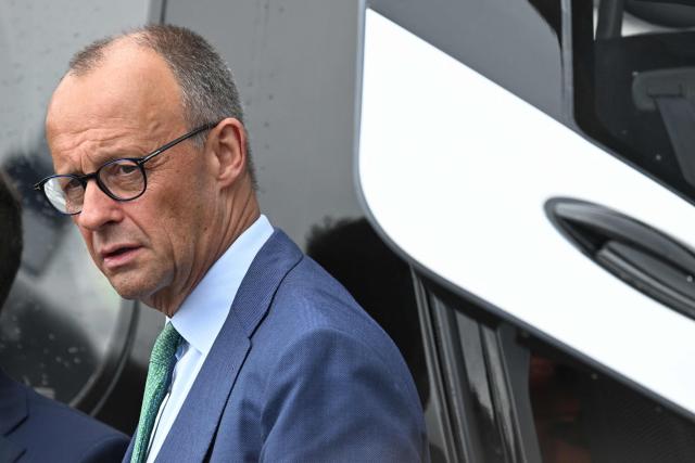 German Chancellor Friedrich Merz is see near an Airbus helicopter during a visit at the International Aerospace Exhibition (ILA) in Schoenefeld, near Berlin on June 10, 2026. Born on May 9, 2026 'Broetchen' is the last addition to the pygmy hippopotamus family at the Zoo in the German capital. (Photo by RALF HIRSCHBERGER / AFP)