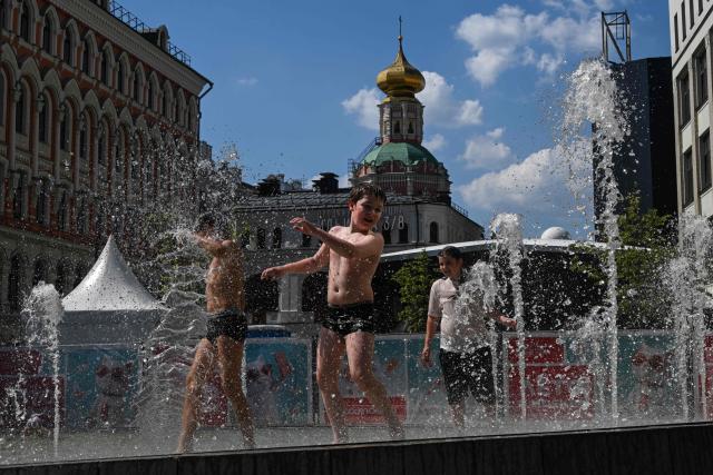 Children cool themselves in a fountain during a hot day in central Mosocow on June 10, 2026. (Photo by Igor IVANKO / AFP)