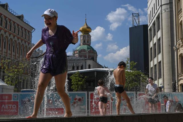 Children cool themselves in a fountain during a hot day in central Mosocow on June 10, 2026. (Photo by Igor IVANKO / AFP)