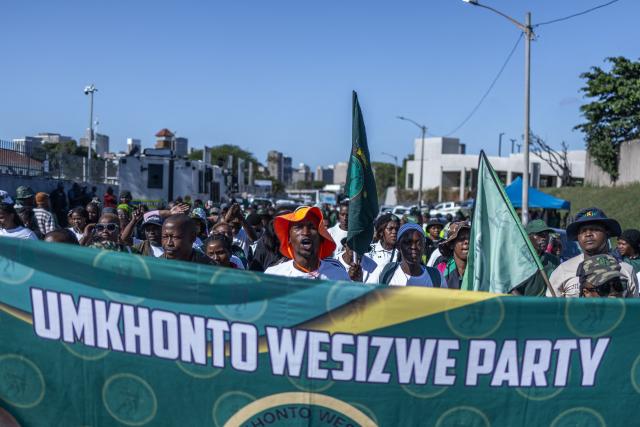 Supporters of the uMkhonto we Sizwe (MK) Party hold a banner as the sing and chant slogans during a protest march in Durban on June 10, 2026. (Photo by RAJESH JANTILAL / AFP)
