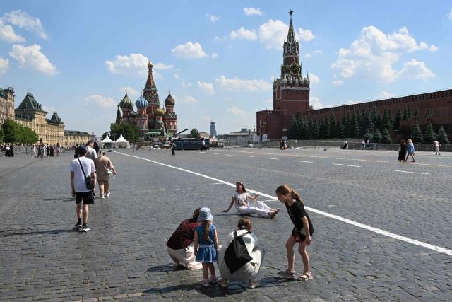 Tourists take pictures with St Basil's Cathedral and the Kremlin's Spasskaya Tower in the background during a hot day in central Moscow on June 10, 2026. (Photo by Igor IVANKO / AFP)