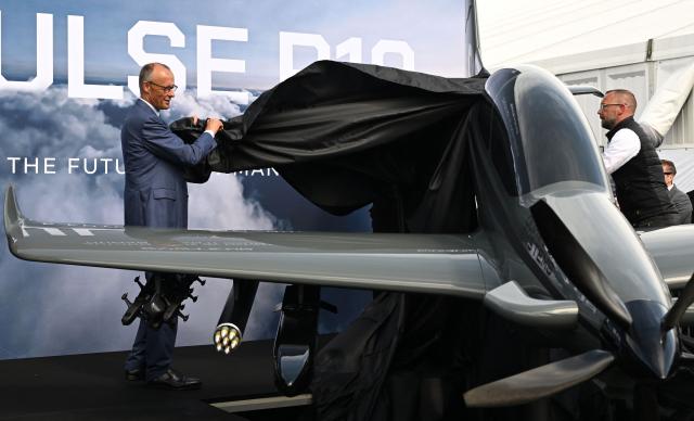 German Chancellor Friedrich Merz attends the unveiling of the PULSE P19 drone, manufactured by German manufacturer of civil and military surveillance drones Quantum-Systems, during his visit at the International Aerospace Exhibition (ILA) in Schoenefeld, near Berlin on June 10, 2026. (Photo by RALF HIRSCHBERGER / AFP)