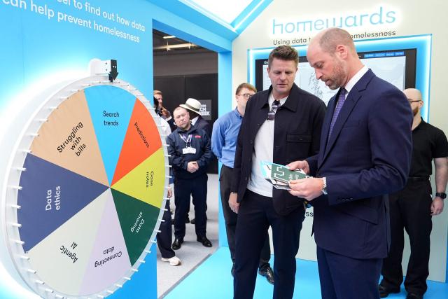 Britain's Prince William, Prince of Wales (R) and English broadcaster Jake Humphrey (2nd R) visit the charity Homewards stand as he attends London Tech Week in London on June 10, 2026, to highlight the role of data and technology in preventing homelessness. (Photo by Aaron Chown / POOL / AFP)