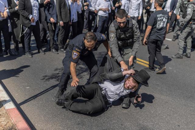 Israeli security forces attempt to disperse ultra-Orthodox Jews trying to block the entrance to the Abu Kabir holding facility in Tel Aviv in protest against the recent arrests of ultra-Orthodox draft dodgers on June 10, 2026. Israel's High Court of Justice in April ordered the state to cut financial benefits to ultra-Orthodox Jews who dodge being drafted and to start criminal proceedings against them. There is a long-standing exemption from compulsory national service for ultra-Orthodox men who engage in full-time religious study, which dates back to Israel's founding in 1948. However, the Supreme Court has repeatedly challenged the exemption in recent years, culminating in a 2024 ruling that the government must conscript ultra-Orthodox men. (Photo by ilia YEFIMOVICH / AFP)