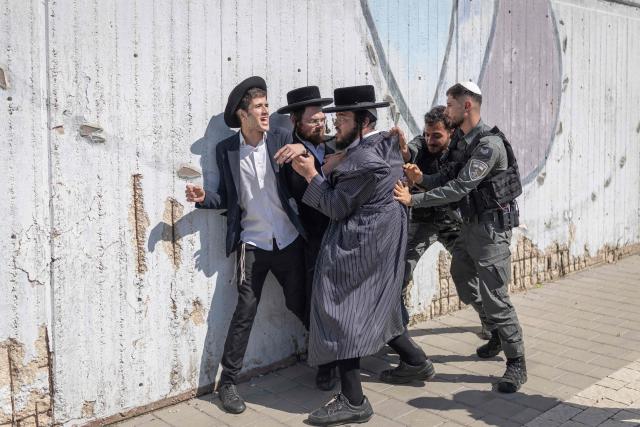 Israeli security forces attempt to disperse ultra-Orthodox Jews trying to block the entrance to the Abu Kabir holding facility in Tel Aviv in protest against the recent arrests of ultra-Orthodox draft dodgers on June 10, 2026. Israel's High Court of Justice in April ordered the state to cut financial benefits to ultra-Orthodox Jews who dodge being drafted and to start criminal proceedings against them. There is a long-standing exemption from compulsory national service for ultra-Orthodox men who engage in full-time religious study, which dates back to Israel's founding in 1948. However, the Supreme Court has repeatedly challenged the exemption in recent years, culminating in a 2024 ruling that the government must conscript ultra-Orthodox men. (Photo by ilia YEFIMOVICH / AFP)