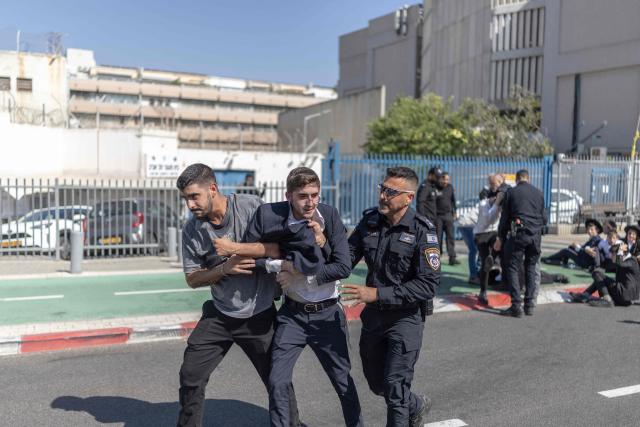 Israeli security forces attempt to disperse ultra-Orthodox Jews trying to block the entrance to the Abu Kabir holding facility in Tel Aviv in protest against the recent arrests of ultra-Orthodox draft dodgers on June 10, 2026. Israel's High Court of Justice in April ordered the state to cut financial benefits to ultra-Orthodox Jews who dodge being drafted and to start criminal proceedings against them. There is a long-standing exemption from compulsory national service for ultra-Orthodox men who engage in full-time religious study, which dates back to Israel's founding in 1948. However, the Supreme Court has repeatedly challenged the exemption in recent years, culminating in a 2024 ruling that the government must conscript ultra-Orthodox men. (Photo by ilia YEFIMOVICH / AFP)