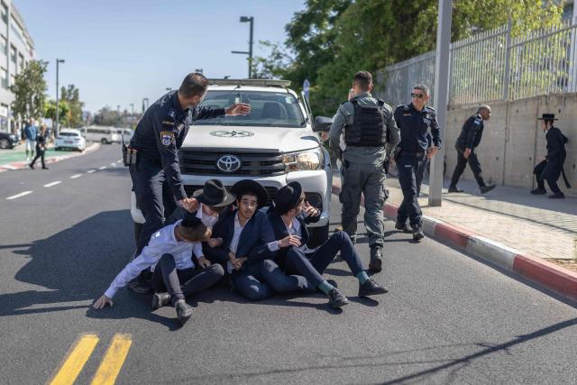 Israeli security forces attempt to disperse ultra-Orthodox Jews trying to block the entrance to the Abu Kabir holding facility in Tel Aviv in protest against the recent arrests of ultra-Orthodox draft dodgers on June 10, 2026. Israel's High Court of Justice in April ordered the state to cut financial benefits to ultra-Orthodox Jews who dodge being drafted and to start criminal proceedings against them. There is a long-standing exemption from compulsory national service for ultra-Orthodox men who engage in full-time religious study, which dates back to Israel's founding in 1948. However, the Supreme Court has repeatedly challenged the exemption in recent years, culminating in a 2024 ruling that the government must conscript ultra-Orthodox men. (Photo by ilia YEFIMOVICH / AFP)