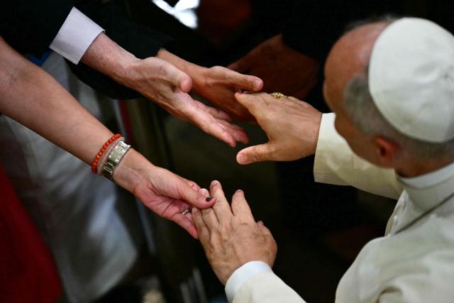 Believers take Pope Leo XIV's hand as he leaves after meeting with Diocesan charity and welfare organizations in the Church of Sant Augusti in Montserrat, near Barcelona, on June 10, 2026. Pope Leo XIV is visiting Spain June 6-12 with stops in Madrid, Barcelona, and the Canary Islands, where he will meet with migrants and organisations dedicated to helping them. (Photo by Stefano RELLANDINI / AFP)