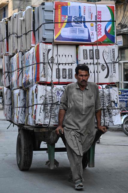 A worker pulls a cart laden with air coolers across a market in Rawalpindi on June 10, 2026. (Photo by Farooq NAEEM / AFP)