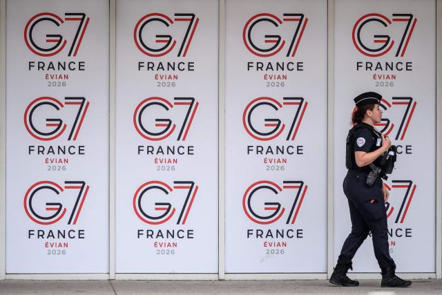 A police officer walks past logos of the G7 summit in Evian, central-eastern France on June 10, 2026. (Photo by Fabrice COFFRINI / AFP)