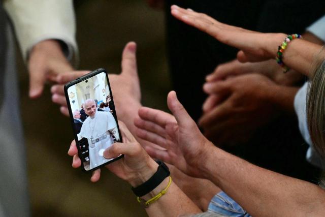 Believers take photos as they try to reach Pope Leo XIV's hand as he leaves after meeting with Diocesan charity and welfare organizations in the Church of Sant Augusti in Montserrat, near Barcelona, on June 10, 2026. Pope Leo XIV is visiting Spain June 6-12 with stops in Madrid, Barcelona, and the Canary Islands, where he will meet with migrants and organisations dedicated to helping them. (Photo by Stefano RELLANDINI / AFP)