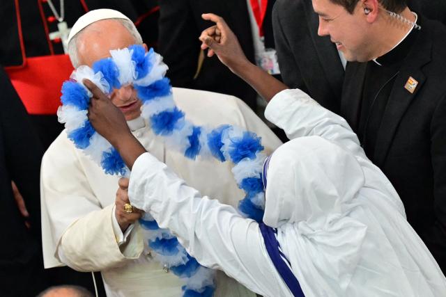 A nun of the Missionaries of Charity order tries to give a garland to Pope Leo XIV, as he leaves after meeting with Diocesan charity and welfare organizations in the Church of Sant Augusti in Montserrat, near Barcelona, on June 10, 2026. Pope Leo XIV is visiting Spain June 6-12 with stops in Madrid, Barcelona, and the Canary Islands, where he will meet with migrants and organisations dedicated to helping them. (Photo by Stefano RELLANDINI / AFP)