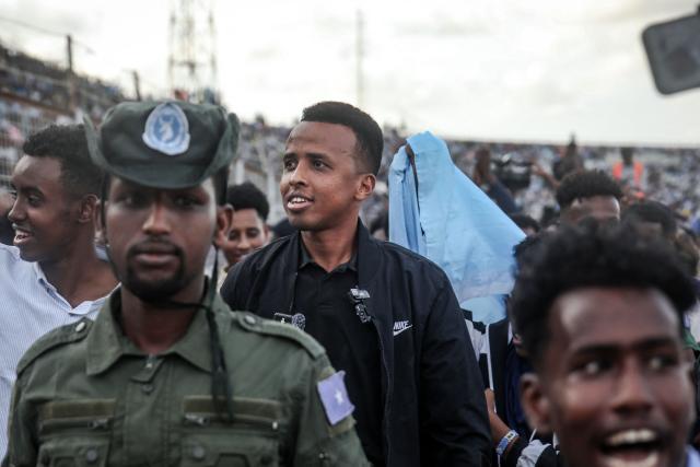 Somali international referee Omar Abdulkadir Artan (C) reacts as he is welcomed by supporters ahead of a solidarity football match after returning to Somalia in Mogadishu on June 10, 2026. Somali referee Omar Artan, who was denied entry to the United States for the World Cup, returned to a hero's welcome in Mogadishu and vowed to take part in the next tournament in 2030. Artan's rejection has sparked outrage at home.Artan, who in 2025 was named men's referee of the year by the Confederation of African Football (CAF), was barred from entering the US on Saturday after arriving at Miami International Airport. (Photo by Hassan Ali Elmi / AFP)