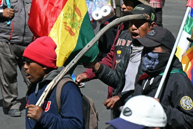 Demonstrators carrying flags and wooden sticks march to protest against the government of Bolivia's President Rodrigo Paz in La Paz on June 10, 2026. For weeks, protesters demanding that US-backed conservative President Rodrigo Paz's fledgling government address a deep economic crisis, while others called for his resignation, have marched and set up roadblocks, bringing Bolivia to a near standstill, driving up food and fuel prices and causing shortages of basic goods. (Photo by AIZAR RALDES / AFP)