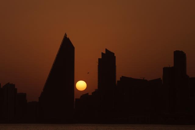 The sun sets behind the Doha skyline on June 10, 2026. (Photo by Karim JAAFAR / AFP)