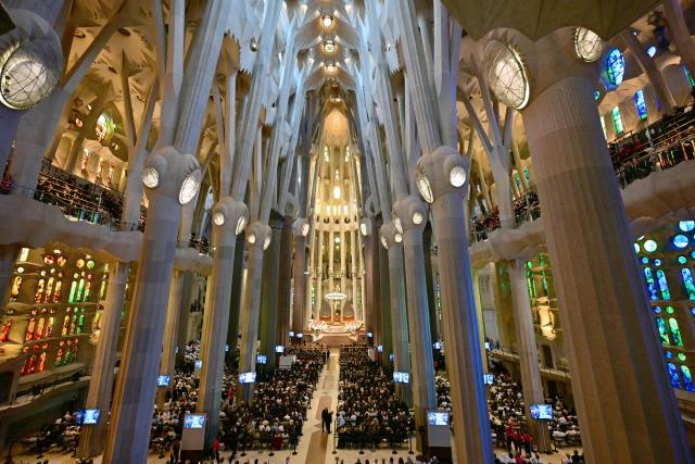 Attendees await the arrival of Pope Leo XIV to lead Holy Mass in the Basilica of the Sagrada Familia and inauguration of the Jesus Christ tower in Barcelona, on June 10, 2026. Pope Leo XIV is visiting Spain June 6-12 with stops in Madrid, Barcelona, and the Canary Islands, where he will meet with migrants and organisations dedicated to helping them. (Photo by Stefano RELLANDINI / AFP)