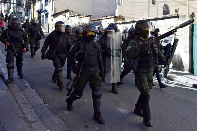 Riot police officers walk along a street during a protest against the government of Bolivia's President Rodrigo Paz in La Paz on June 10, 2026. For weeks, protesters demanding that US-backed conservative President Rodrigo Paz's fledgling government address a deep economic crisis, while others called for his resignation, have marched and set up roadblocks, bringing Bolivia to a near standstill, driving up food and fuel prices and causing shortages of basic goods. (Photo by Jorge BERNAL / AFP)