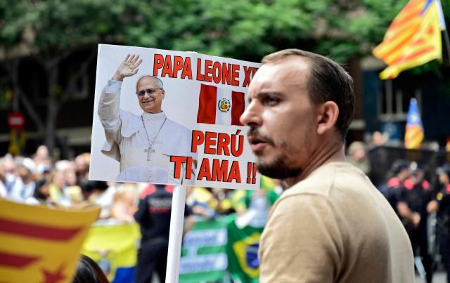 People welcome Pope Leo XIV with a poster meaning "Pope Leo XIV, Peru loves you" as he arrives to lead Holy Mass in the Basilica of the Sagrada Familia and inauguration of the Jesus Christ tower in Barcelona, on June 10, 2026. Pope Leo XIV is visiting Spain June 6-12 with stops in Madrid, Barcelona, and the Canary Islands, where he will meet with migrants and organisations dedicated to helping them. (Photo by Ander Gillenea / AFP)