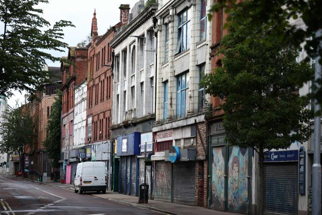 Closed, shuttered shops are pictured on a deserted road in Belfast, Northern Ireland, on June 10, 2026. Northern Ireland braced Wednesday for a potential second night of violence directed at immigrants, following unrest that UK authorities say was stoked by far-right activists on social media after a brutal Belfast stabbing. (Photo by Henry NICHOLLS / AFP)