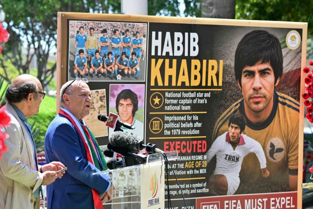 Yousef Safarloo (2L), former Iranian soccer player, speaks during a press conference held by the National Council of Resistance of Iran, who is calling on FIFA to suspend and expel the Iranian regime-controlled "Football Federation Islamic Republic of Iran" from international football, at Los Angeles City Hall, in Los Angeles, on June 10, 2026. (Photo by Frederic J. Brown / AFP)