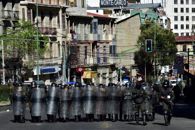 Riot police officers take cover behind shields during a protest against the government of Bolivia's President Rodrigo Paz in La Paz on June 10, 2026. For weeks, protesters demanding that US-backed conservative President Rodrigo Paz's fledgling government address a deep economic crisis, while others called for his resignation, have marched and set up roadblocks, bringing Bolivia to a near standstill, driving up food and fuel prices and causing shortages of basic goods. (Photo by Jorge BERNAL / AFP)