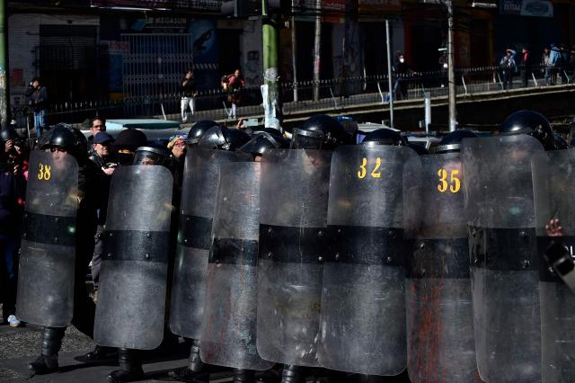 Riot police officers take cover behind shields during a protest against the government of Bolivia's President Rodrigo Paz in La Paz on June 10, 2026. For weeks, protesters demanding that US-backed conservative President Rodrigo Paz's fledgling government address a deep economic crisis, while others called for his resignation, have marched and set up roadblocks, bringing Bolivia to a near standstill, driving up food and fuel prices and causing shortages of basic goods. (Photo by Jorge BERNAL / AFP)
