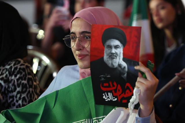 A supporter of Iran-backed armed group Hezbollah, holds a portrait of slain leader Hassan Nasrallah during an anti-US and anti-Israel protest organised by the International Popular Committees to Resist Aggression in Beirut’s southern suburbs on June 10, 2026. Israeli airstrikes on Lebanon killed at least 12 people on June 10, a medical source told AFP, as Israeli Prime Minister Benjamin Netanyahu urged the Lebanese people to join Israel's fight against Hezbollah. (Photo by Anwar AMRO / AFP) / 