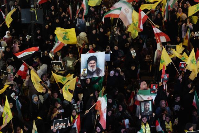 Supporters of Iran-backed armed group Hezbollah, wave flags and hold a portrait of slain leader Hassan Nasrallah during an anti-US and anti-Israel protest organised by the International Popular Committees to Resist Aggression in Beirut’s southern suburbs on June 10, 2026. Israeli airstrikes on Lebanon killed at least 12 people on June 10, a medical source told AFP, as Israeli Prime Minister Benjamin Netanyahu urged the Lebanese people to join Israel's fight against Hezbollah. (Photo by Anwar AMRO / AFP) / 