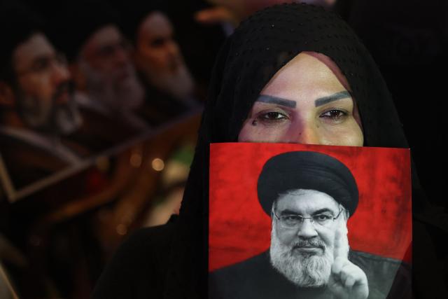 A supporter of Iran-backed armed group Hezbollah, holds a portrait of slain leader Hassan Nasrallah during an anti-US and anti-Israel protest organised by the International Popular Committees to Resist Aggression in Beirut’s southern suburbs on June 10, 2026. Israeli airstrikes on Lebanon killed at least 12 people on June 10, a medical source told AFP, as Israeli Prime Minister Benjamin Netanyahu urged the Lebanese people to join Israel's fight against Hezbollah. (Photo by Anwar AMRO / AFP) / 