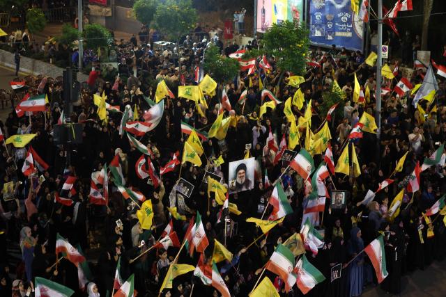 Supporters of Iran-backed armed group Hezbollah, wave flags and hold a portrait of slain leader Hassan Nasrallah during an anti-US and anti-Israel protest organised by the International Popular Committees to Resist Aggression in Beirut’s southern suburbs on June 10, 2026. Israeli airstrikes on Lebanon killed at least 12 people on June 10, a medical source told AFP, as Israeli Prime Minister Benjamin Netanyahu urged the Lebanese people to join Israel's fight against Hezbollah. (Photo by Anwar AMRO / AFP) / 