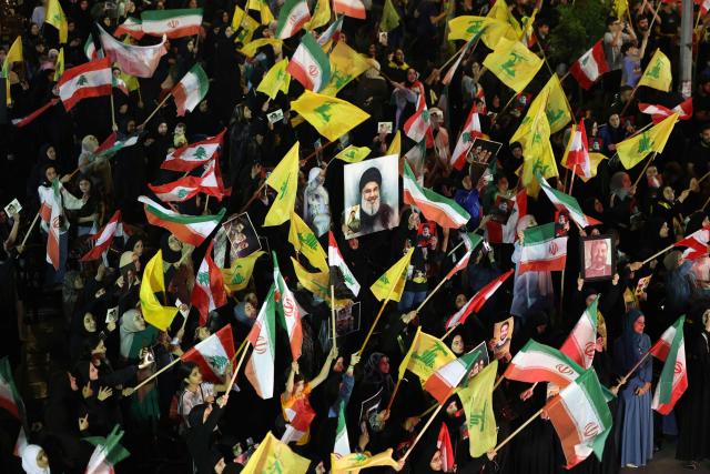Supporters of Iran-backed armed group Hezbollah, wave flags and hold a portrait of slain leader Hassan Nasrallah during an anti-US and anti-Israel protest organised by the International Popular Committees to Resist Aggression in Beirut’s southern suburbs on June 10, 2026. Israeli airstrikes on Lebanon killed at least 12 people on June 10, a medical source told AFP, as Israeli Prime Minister Benjamin Netanyahu urged the Lebanese people to join Israel's fight against Hezbollah. (Photo by Anwar AMRO / AFP) / 
